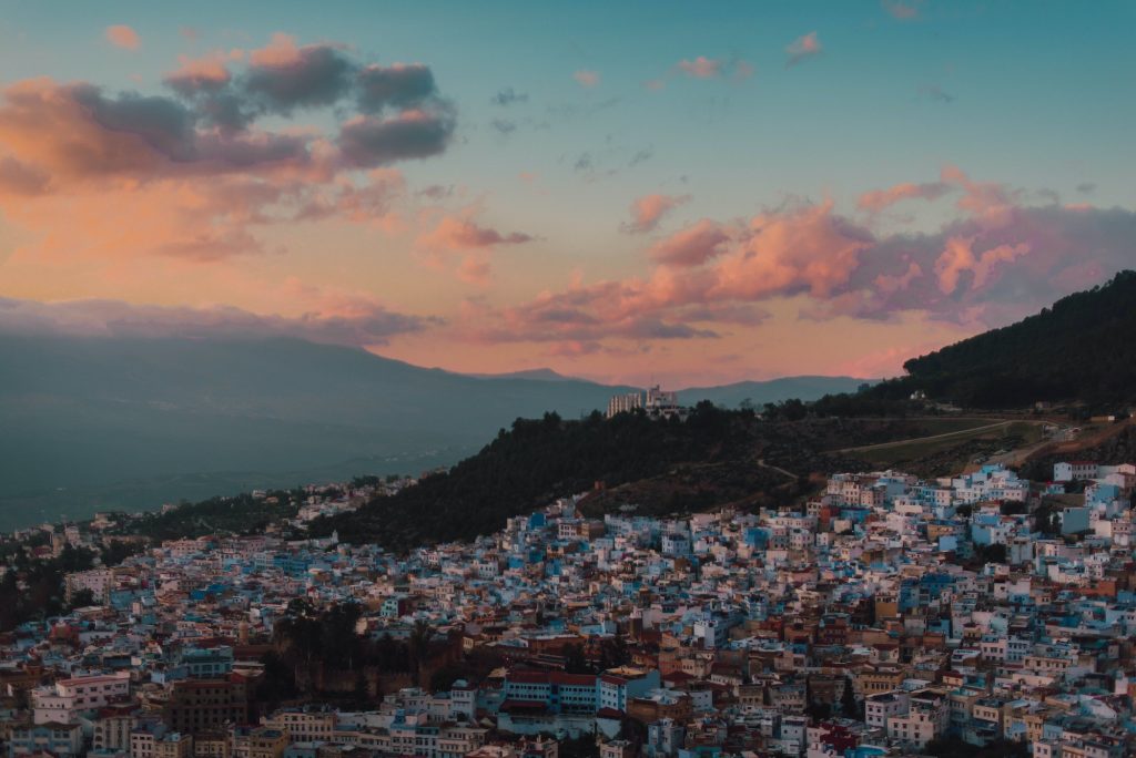 Cityscape on hill and clouds with sun