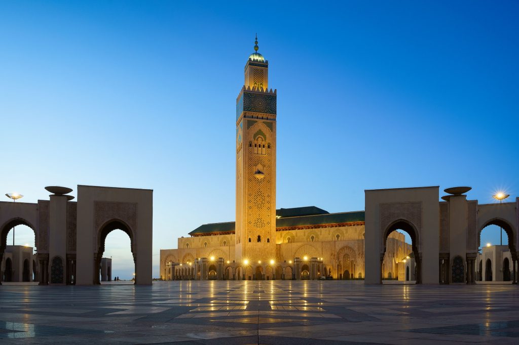 Illuminated Hassan II Mosque with its reflection on the stoned ground in Casablanca, Morocco